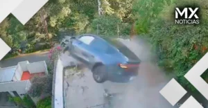 VIDEO| Tesla derriba portón, atraviesa una casa y cae en otra vivienda en la CDMX